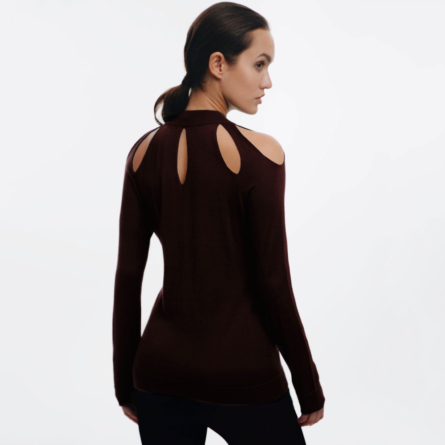 Woman wearing a brown long-sleeve Cashmere sweater with cut-out design on the back